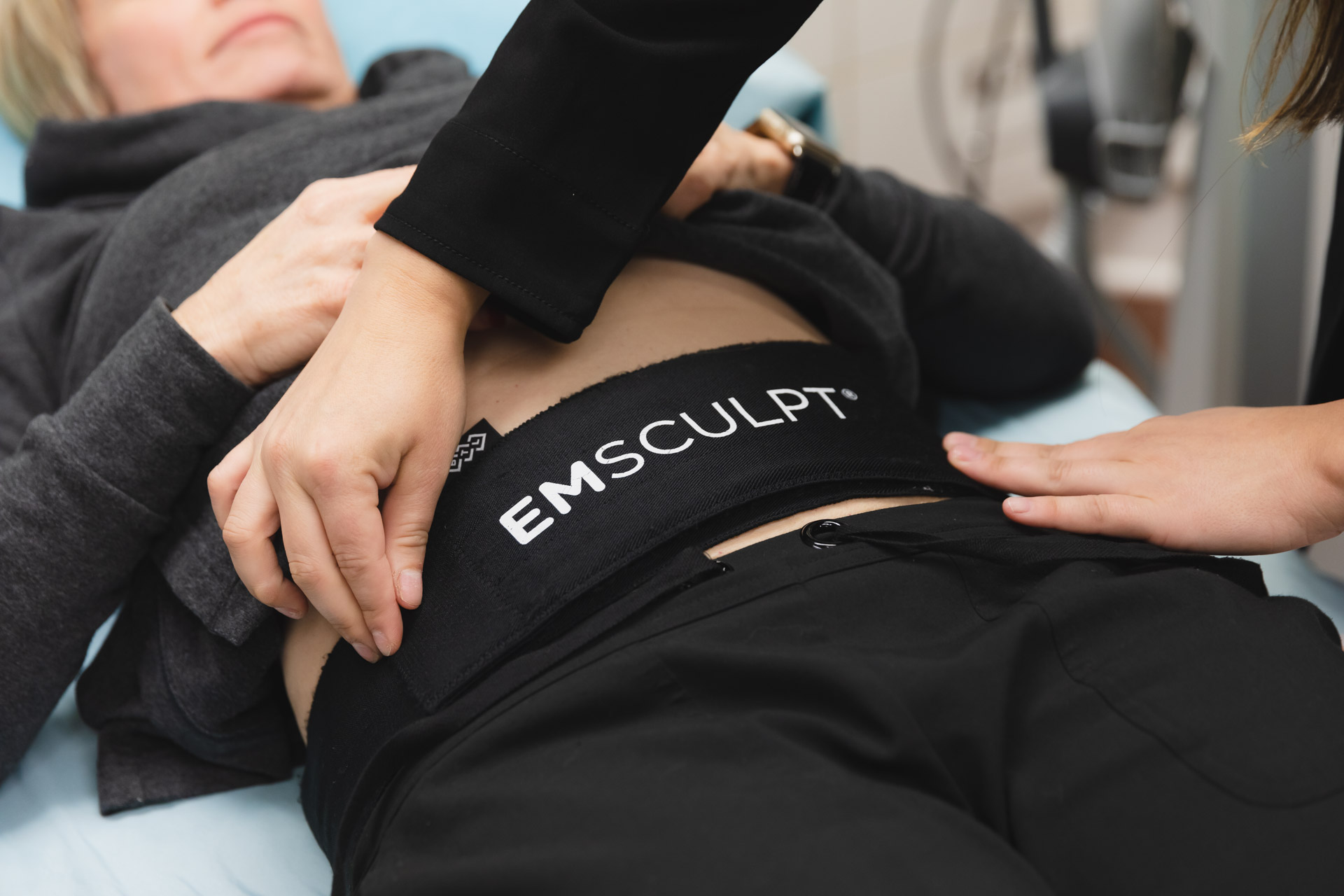 Emsculpt Neo body contouring treatment at CATARA Medical Spa in Algonquin showing the device applicator positioned on a client's abdomen during a non-invasive muscle building and fat reduction session