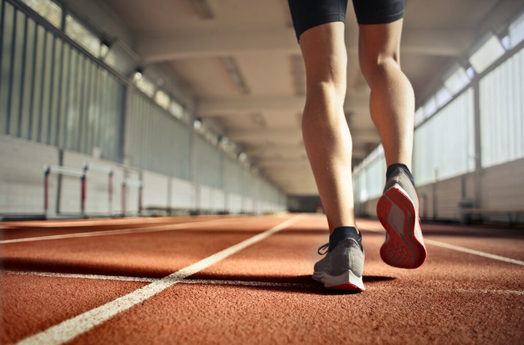 Runner walking on indoor track representing athletic recovery and performance support at Catara Med Spa in Algonquin, IL.