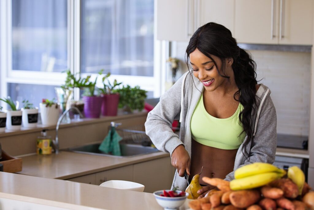 Healthy woman preparing fruit, representing personalized nutrition coaching and weight loss programs at Catara Med Spa in Algonquin, IL