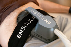Close-up of EM Sculpt Neo applicator delivering electromagnetic pulses to a patient's abdomen at CATARA Medical Spa, demonstrating what EM Sculpt technology looks like during treatment