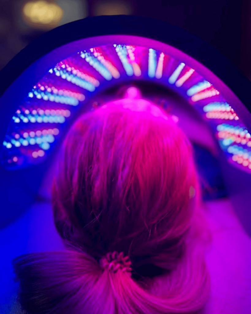 Client positioned under LED panel during a blue light therapy session at Catara Med Spa in Algonquin, IL.
