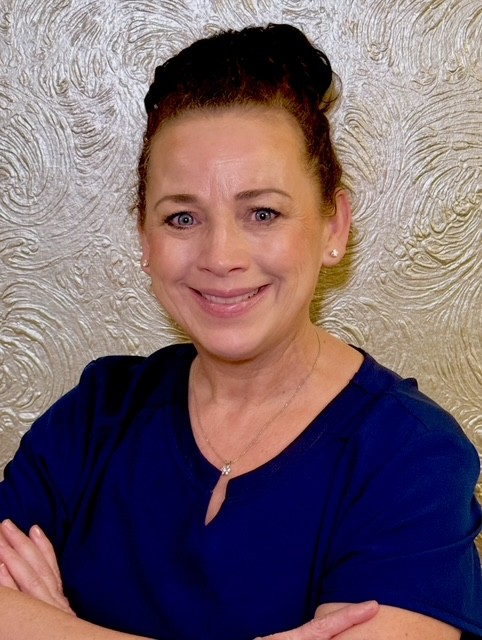licensed aesthetic nurse at catara med spa in algonquin il smiling in front of textured gold wall professional skincare provider portrait