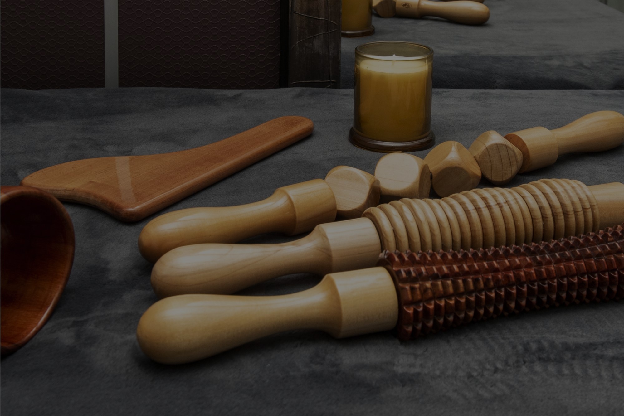 Wooden therapy massage tools displayed on a spa bed at Catara Med Spa in Algonquin, IL for body sculpting sessions.