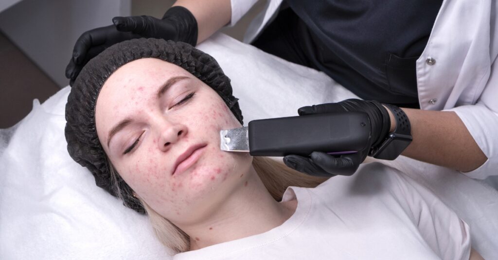 Woman examining her skin in the mirror after dermaplaning treatment at Catara Med Spa in Algonquin, IL. Smooth, radiant results without thicker hair regrowth.